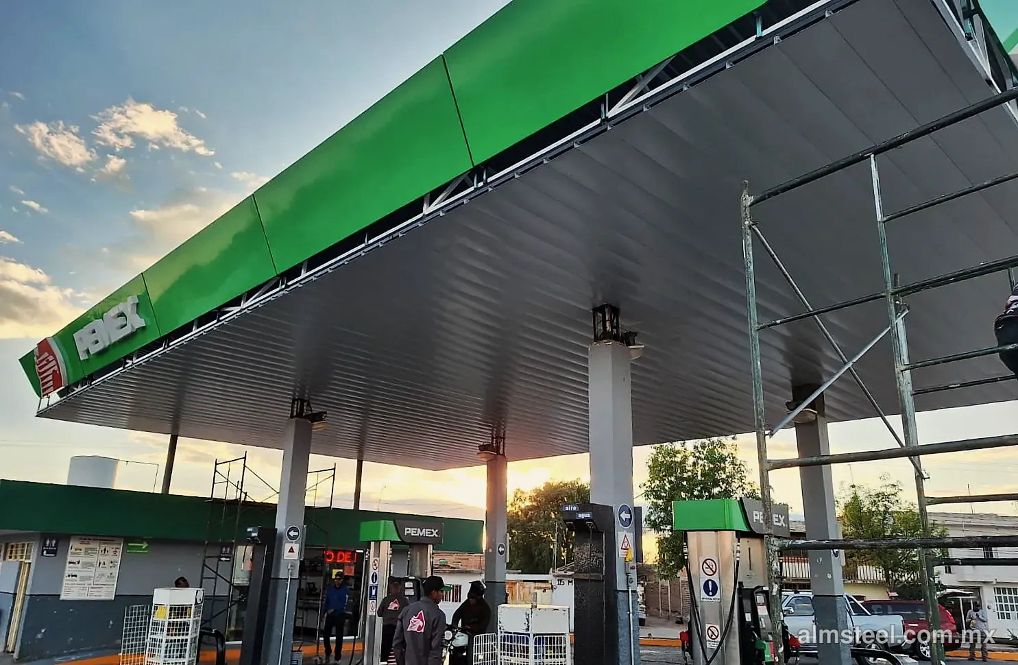 Plafón metálico blanco bajo la techumbre de la gasolinera al atardecer