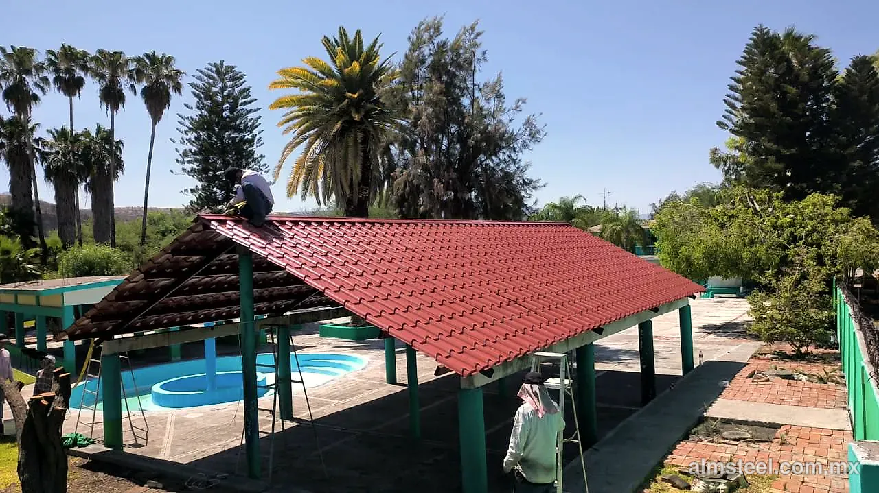 Palapa con teja española roja junto a la alberca, durante la instalación